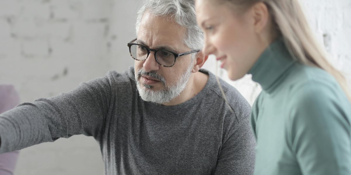 A manager providing guidance to a team member, symbolizing internal upskilling and career development in cloud technology.