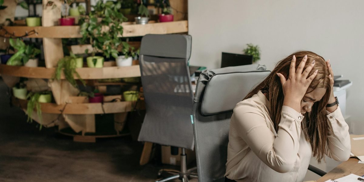 A person looking frustrated amidst a cluttered workspace, symbolizing the challenge of disconnected tools and data silos.