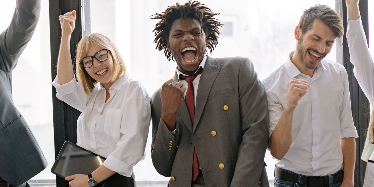 A business team celebrating a successful project, indicative of achieving measurable ROI and KPIs with AI initiatives.