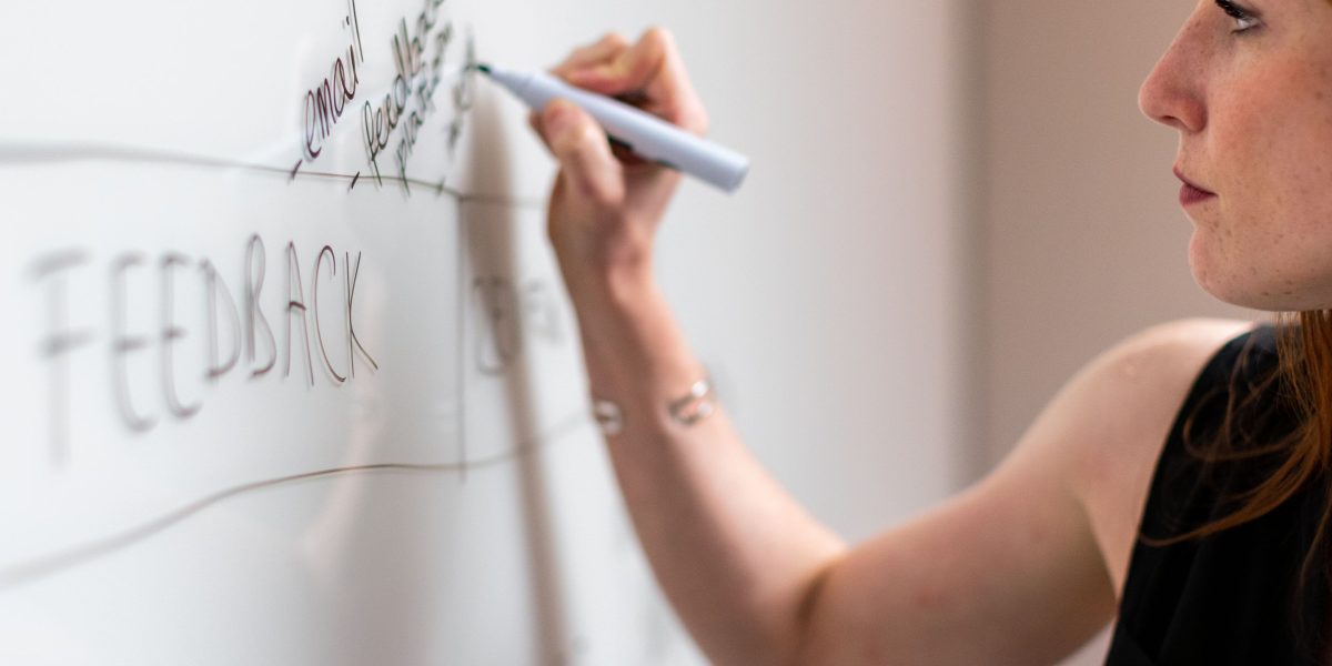 A person actively outlining a plan on a whiteboard, symbolizing the process of building a structured AI learning roadmap.
