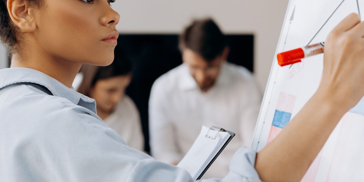 A leader outlines strategic IT asset management initiatives on a whiteboard to ensure safe and smart business operations.