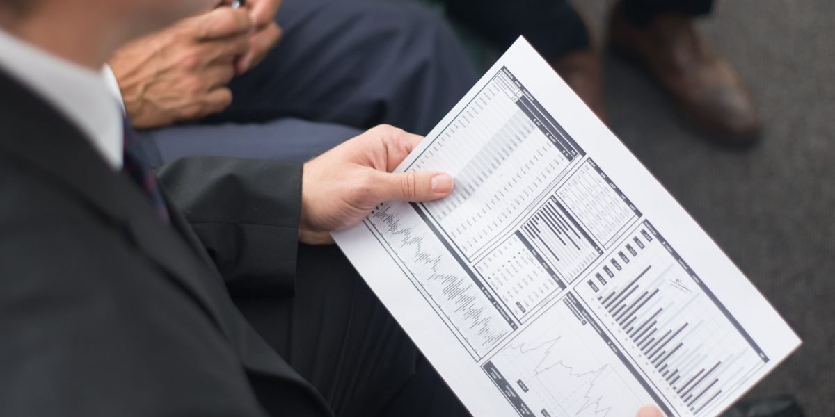 A confident business manager reviews a performance report, assessing the success of a major project.