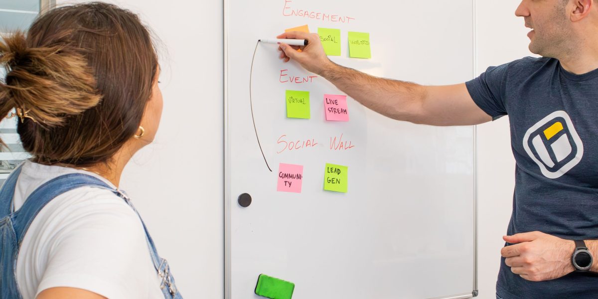 A diverse team actively brainstorming ideas and solutions using a whiteboard in a collaborative environment.