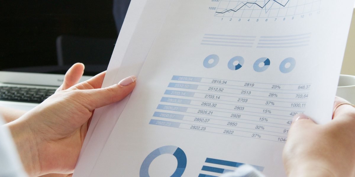 A person reviewing financial documents and charts, focused on budgeting and cost management.