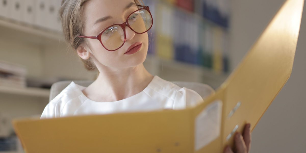 A professional reviewing important compliance documents, ensuring adherence to standards and regulations.