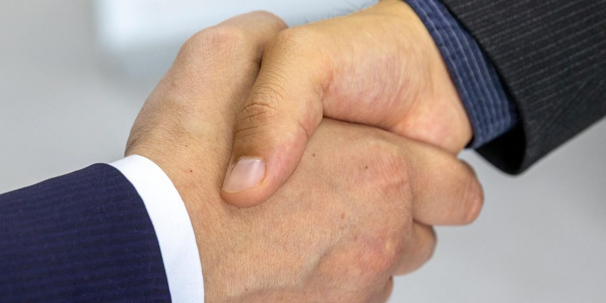 A handshake between two professionals, symbolizing a successful interview, internship placement, or job offer.